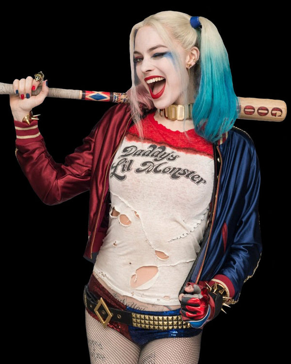 Person in Harley Quinn costume holding a baseball bat with a black background