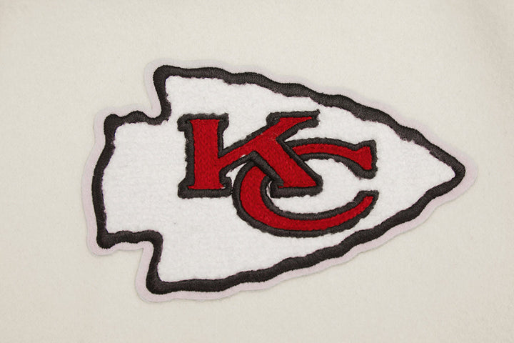 Close-up of KC arrowhead logo on Kansas City Chiefs wool varsity jacket.